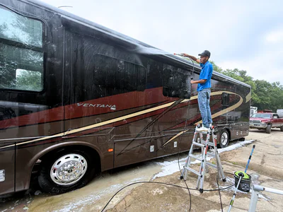 RV exterior detailing showing professional technician working on large recreational vehicle
