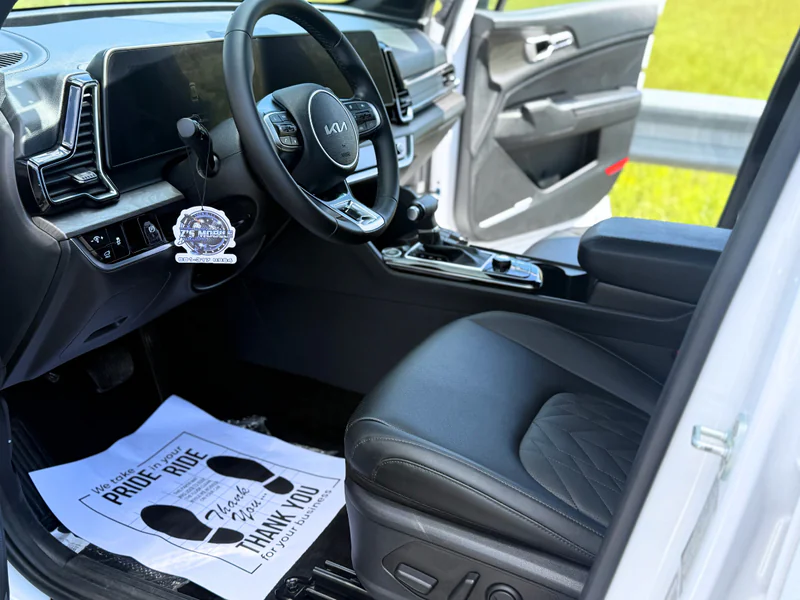 Professional interior detailing service - pristine Kia interior showing steering wheel and floor mat transformation