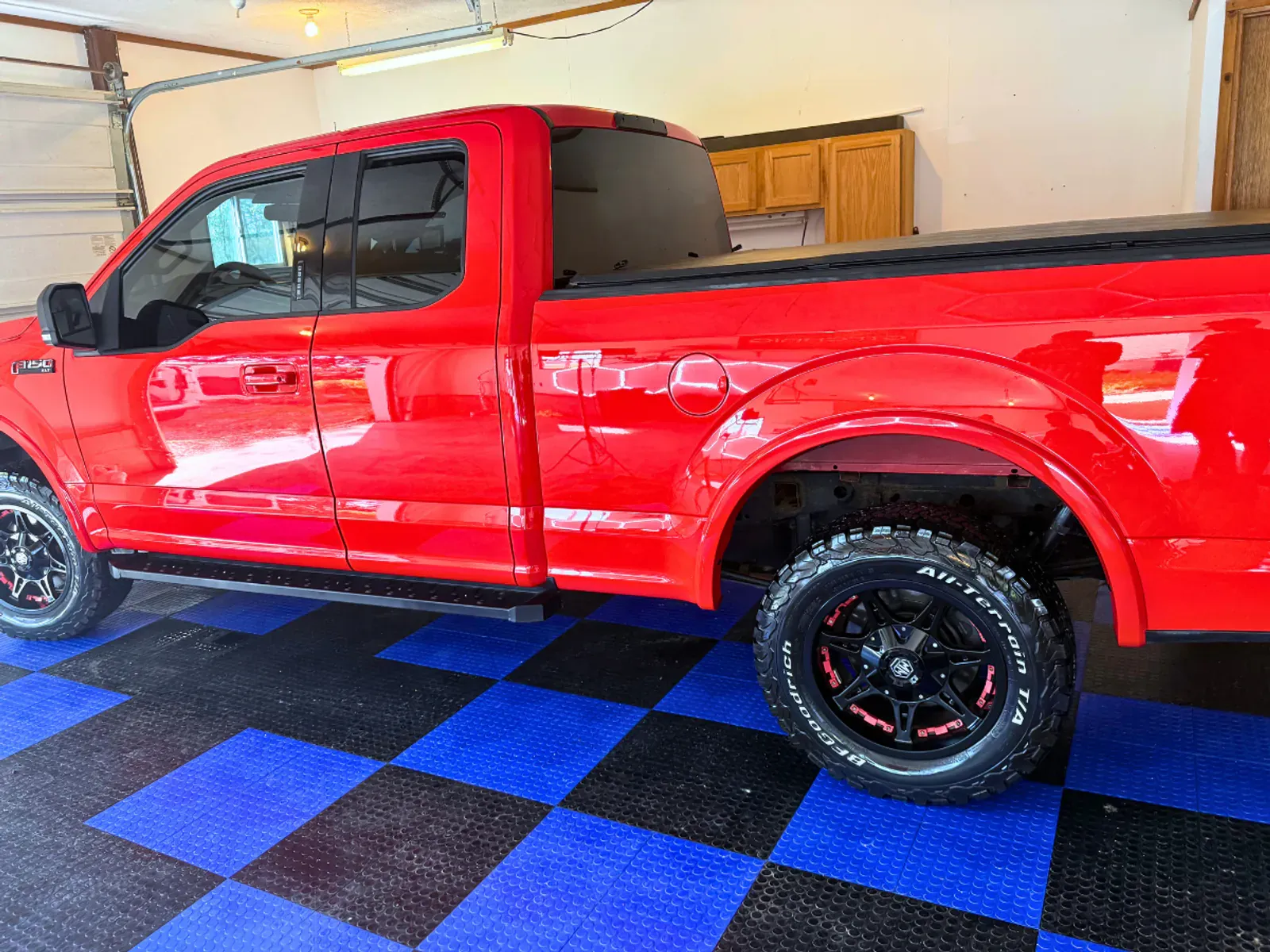 Red Ford F-150 rear angle showing ceramic coating shine and water beading